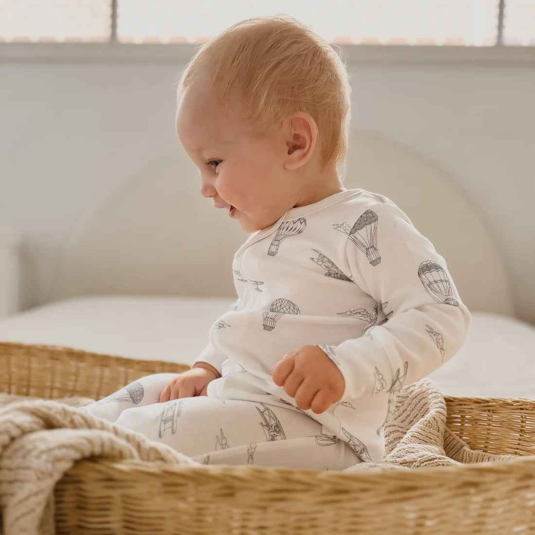 Baby Zip romper in soft organic cotton. Gorgeous design of blue planes and hot air balloons on a white background.