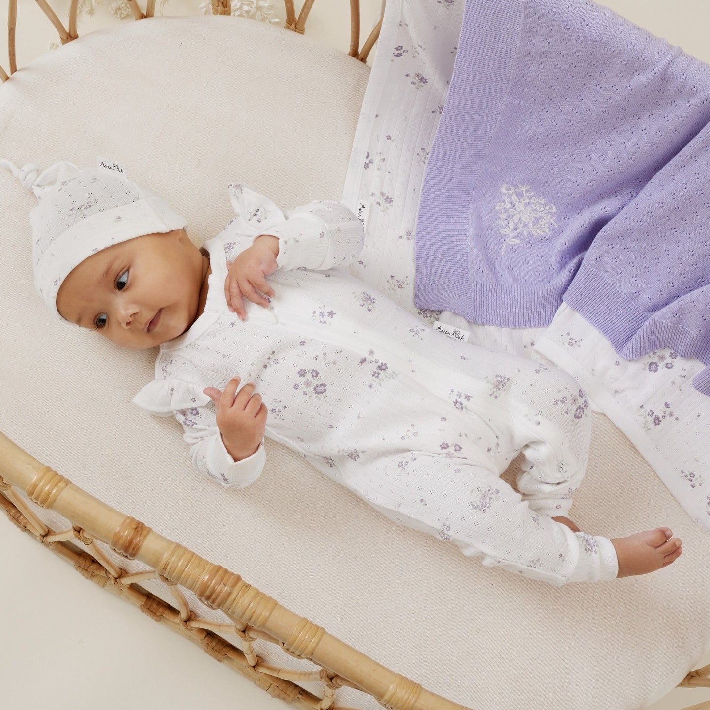 Organic Zip romper in a gorgeous lilac floral on white background.