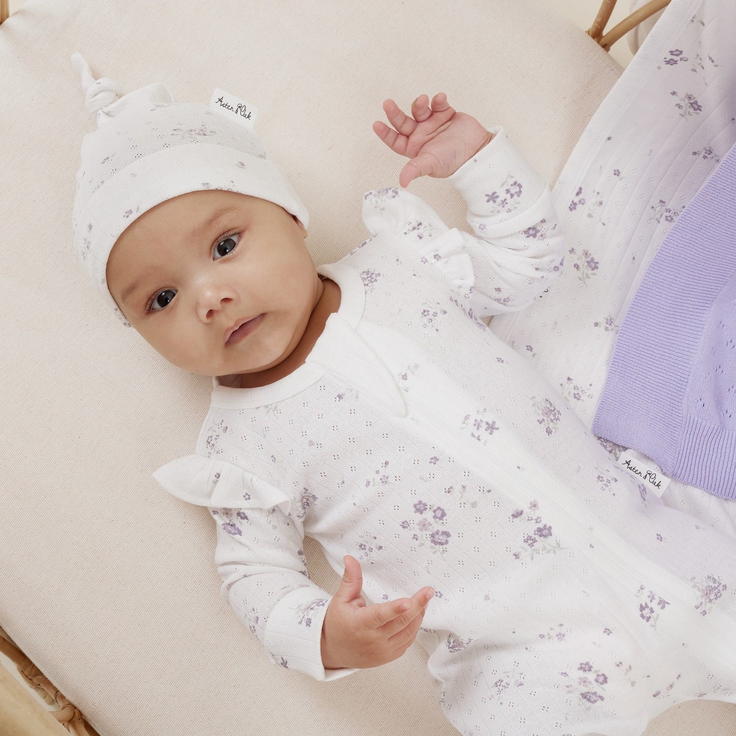 Organic Zip romper in a gorgeous lilac floral on white background.