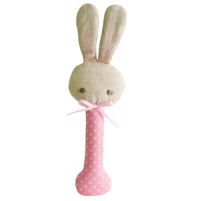 Pink baby rattle with white spot on pink.